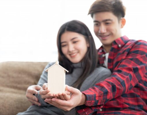 selective focus hand s young couple holding mini wooden house sofa bedroom 1150 15508