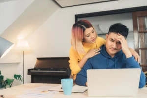 Couple using a laptop to check their mortgage stress test numbers